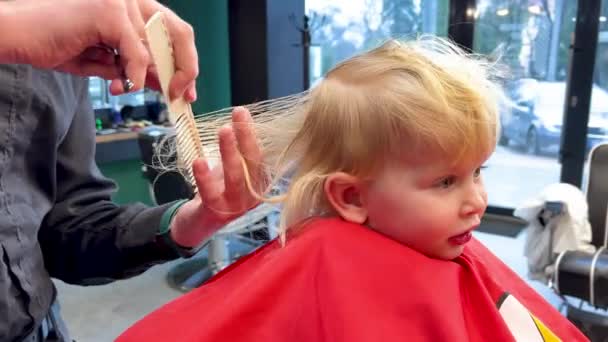 Mann Schneidet Kleinen Jungen Haare Mit Kamm Und Schere Kind — Stockvideo