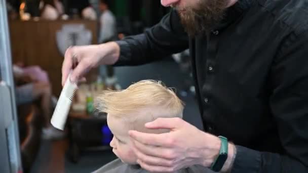 Чоловік Перукар Ріже Маленьких Хлопчиків Волосся Допомогою Гребінця Ножиць Дитина — стокове відео