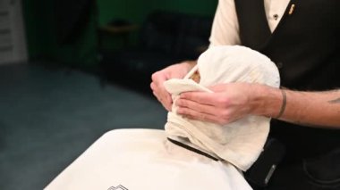 Profesyonel berber müşterilerin sakallarını tıraş ediyor..