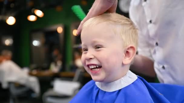 Чоловік Перукар Ріже Маленьких Хлопчиків Волосся Допомогою Гребінця Ножиць Крупним — стокове відео
