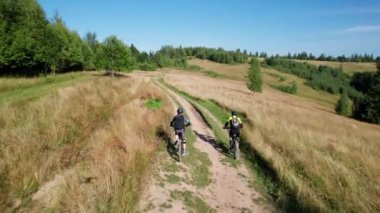 Dışarıda bisiklete binen iki bisikletçi. Erkek turistlerin dağlarda bisiklet sürerken, kask takıp sırt çantaları taktıklarını gördüm. Spor anlayışı, aktif eğlence ve doğa.