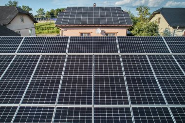 Aerial top view of new modern house cottage with solar photovoltaic panel system on house roof