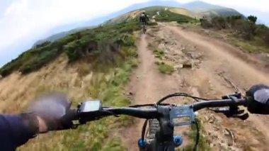 Bakış açısı. Dağlarda elektrikli dağ bisikleti süren iki bisikletçi. Macera kavramı, dışarıda boş zaman geçirmek..