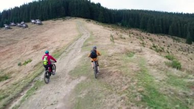 Dışarıda bisiklete binen iki bisikletçi. Erkek turistlerin dağlarda bisiklet sürerken, kask takıp sırt çantaları taktıklarını gördüm. Spor anlayışı, aktif eğlence ve doğa.