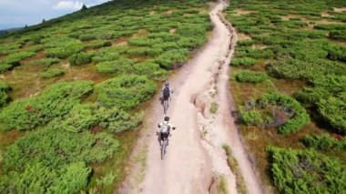 Dışarıda bisiklete binen iki bisikletçi. Erkek turistlerin dağlarda bisiklet sürerken, kask takıp sırt çantaları taktıklarını gördüm. Spor anlayışı, aktif eğlence ve doğa.