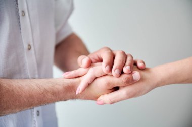 Hassas dokunuşlar yapan iki ele yaklaş. Erkekler ve kadınlar beyaz tarafsız bir arkaplanda el ele tutuşurlar. Sevgili eşinin elini tutan koca. Aşk kavramı, samimiyet, destek ve güven..