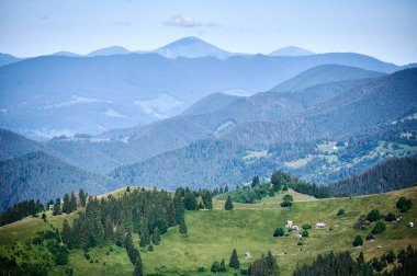 Yuvarlanan dağların dingin güzelliği yemyeşil çayırlar ve küçük kırsal evlerle dolu verimli ormanlarla kaplıdır. Dağların katmanları mesafeye kadar uzanıyor ve manzaralar yaratıyor..