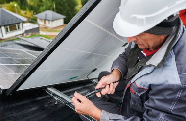 PV güneş panelinin kablolarını bağlayan profesyonel mühendis. Erkek işçi güneş pilini çalışmaya hazırlıyor. Modern yaşamda alternatif elektrik kaynakları. Kapat.