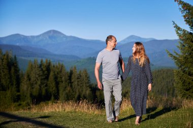 Çiftler el ele tutuşur, çayırlarda çıplak ayakla yürürler, çarpıcı dağ manzarasının tadını çıkarırlar. Berrak mavi gökyüzünün altında yemyeşil orman ve uzak dağlar dingin ve romantik bir atmosfer yaratır..