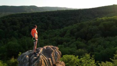 Ukrayna 'daki Karpat Dağları' ndaki Dovbush Kayalıkları 'ndaki kaya oluşumunun havada görünen görüntüsü. Güneş batıyor, yemyeşil orman, uzak tepeler üzerine ılık bir parıltı saçıyor, nefes kesici bir manzara yaratıyor..
