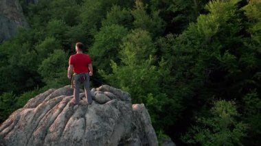 Ukrayna 'daki Karpat Dağları' ndaki Dovbush Kayalıkları 'ndaki kaya oluşumunun havada görünen görüntüsü. Güneş batıyor, yemyeşil orman, uzak tepeler üzerine ılık bir parıltı saçıyor, nefes kesici bir manzara yaratıyor..