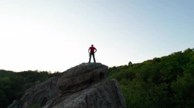 Ukrayna 'daki Karpat Dağları' ndaki Dovbush Kayalıkları 'ndaki kaya oluşumunun havada görünen görüntüsü. Güneş batıyor, yemyeşil orman, uzak tepeler üzerine ılık bir parıltı saçıyor, nefes kesici bir manzara yaratıyor..