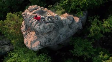 Ukrayna 'daki Karpat Dağları' ndaki Dovbush Kayalıkları 'ndaki kaya oluşumunun havada görünen görüntüsü. Güneş batıyor, yemyeşil orman, uzak tepeler üzerine ılık bir parıltı saçıyor, nefes kesici bir manzara yaratıyor..