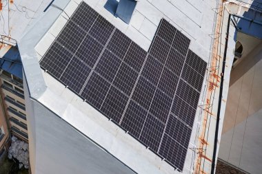 Çatıda fotovoltaik etkiyle elektrik üretmek için güneş panelleri olan bir ev. Çatıda güneş enerjisi sistemi olan bir ev. Alternatif enerji kavramı, özerklik, güç sürdürülebilir kaynaklar.