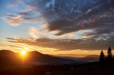 Güneş tepelerin ardından yükselir, gökyüzünde dramatik bulutlarla dolu altın bir parıltı yayar. Aşağıdaki vadi sisle aydınlanıyor, sabahları huzur ve resim manzarasını geliştiriyor..