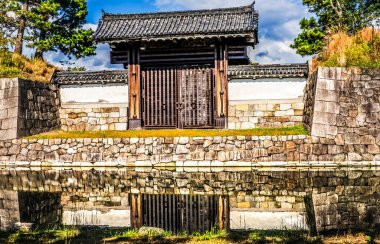 Colorful Small Side Entrance Outer Wall Moat Reflection City Street Nijo Castle Kyoto Japan. Completed in 1626 by Tokugawa Shoguns. In 1867 Castle returned to Emperor.  clipart