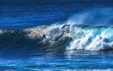 Renkli Sörfçü Yeşil Oda Büyük Dalga Banzai Boru Hattı Kuzey Sahil Oahu Hawaii. Sığ resifin üzerindeki dev dalgalar, sörfçülerin binebileceği büyük, içi boş su kıvrımları oluşturur. Sığ resif sörf yapmak için tehlikeli ve güzel bir yer yaratır..