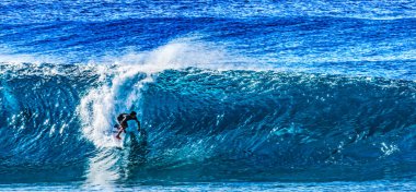 Renkli Sörfçü Yeşil Oda Büyük Dalga Banzai Boru Hattı Kuzey Sahil Oahu Hawaii. Sığ resifin üzerindeki dev dalgalar, sörfçülerin binebileceği büyük, içi boş su kıvrımları oluşturur. Sığ resif sörf yapmak için tehlikeli ve güzel bir yer yaratır..