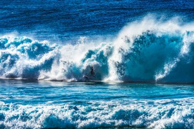 Renkli Sörfçü Yeşil Oda Büyük Dalga Banzai Boru Hattı Kuzey Sahil Oahu Hawaii. Sığ resifin üzerindeki dev dalgalar, sörfçülerin binebileceği büyük, içi boş su kıvrımları oluşturur. Sığ resif sörf yapmak için tehlikeli ve güzel bir yer yaratır..