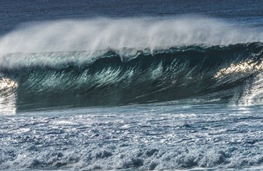 Büyük Dalga Banzai Boru Hattı Kuzey Kıyısı Oahu Hawaii 'yi izliyor. Yüzeysel Resifin Üzerindeki Dev Dalgalar, sörfçülerin binebileceği büyük, oyuk ve kalın su kıvrımları oluşturur. Sığ resif sörf yapmak için tehlikeli ve güzel bir yer yaratır..