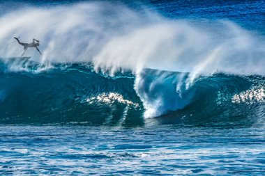Renkli Sörfçü Düşen Büyük Dalga Banzai Boru Hattı Kuzey Kıyısı Oahu Hawaii. Sığ resifin üzerindeki dev dalgalar sörfçülerin sürdüğü içi boş su kıvrımları yaratır. Sığ resif sörf yapmak için tehlikeli ve güzel bir yer yaratır..