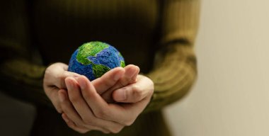 Dünya Günü Kavramı. Yeşil Enerji, ESG, Yenilenebilir ve sürdürülebilir kaynaklar. Çevre ve Ekoloji Bakımı. Yeşil Küre 'yi Saran Kadın Eli, Ön Görünüm