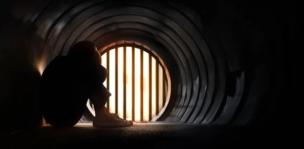 精神疾患の概念 ストレス 憂うつな人暗いトンネルの中の床に座って チューブの終わりに光 負の感情と感情 ムーディーダークトーン — ストック写真