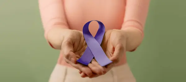 Cancer Awareness Campaign Concept. Global Healthcare. World Cancer Day. Close up of a Young Female Holding a Violet Ribbon into the Front.