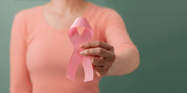 Breast Cancer Awareness Campaign Concept. Women Healthcare. Close up of a Young Female Brings a Pink Ribbon into the Front.