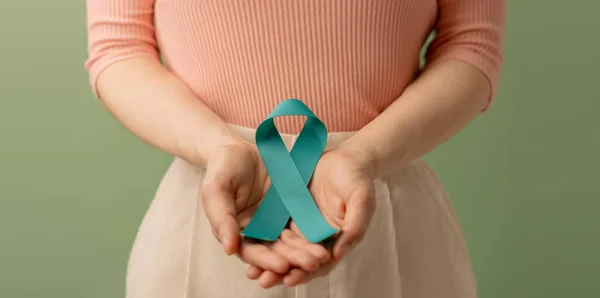 Ovarian and Cervical Cancer Awareness. Woman Holding Teal Ribbon on Lower Abdomen, Uterus, Female Reproductive System, Women\'s Health, PCOS and Gynecology