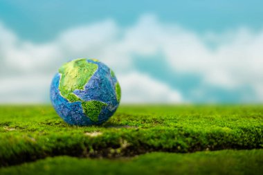 Dünya Günü Kavramı. Yeşil Enerji, ESG, Yenilenebilir ve sürdürülebilir kaynaklar. Çevresel bakım. Yeşil Yosun Küresi ve Bulanık Gökyüzü arka plan olarak