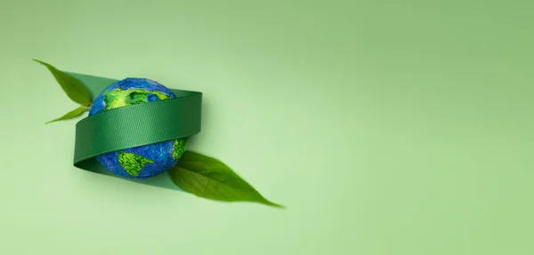 世界地球日的概念 在地球上植树 Esg 可再生和可持续资源 环境护理 绿带和叶子拥抱一个球体 顶视图 免版税图库图片