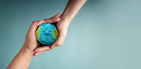 two people holding Happy Smiling Earth symbolizing sustainability, global happiness, environmental care, and ecological responsibility, Top View