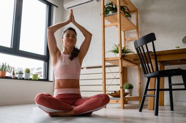 Genç ve güzel bir kadın internetten yoga yapıyor.