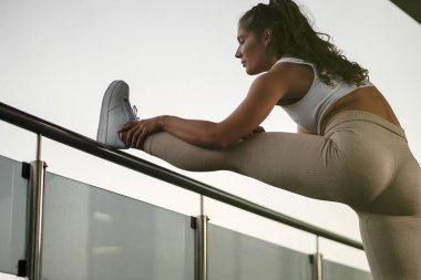 Genç bir kadın çatıda bacaklarını açıyor.