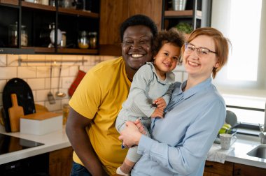 cute multiracal family posing on kitchen