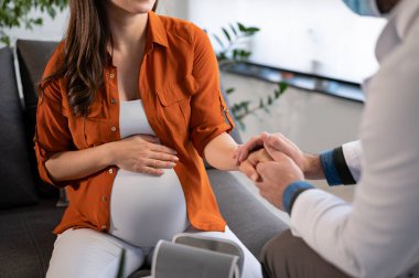 Kontrol için doktoru ziyaret eden hamile bir kadın.