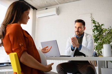 Kontrol için doktoru ziyaret eden hamile bir kadın.