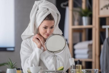 Makyaj yapan genç ve güzel bir kadın.