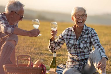 Yaşlı çift dağlarda piknik yapıyor.