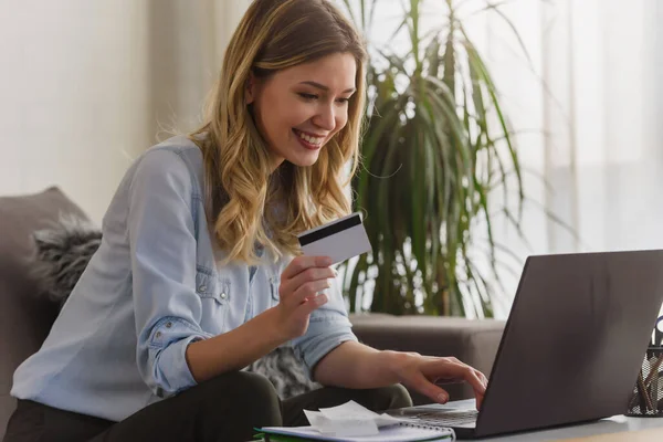 beautiful young woman with laptop and credit card in her office making online order