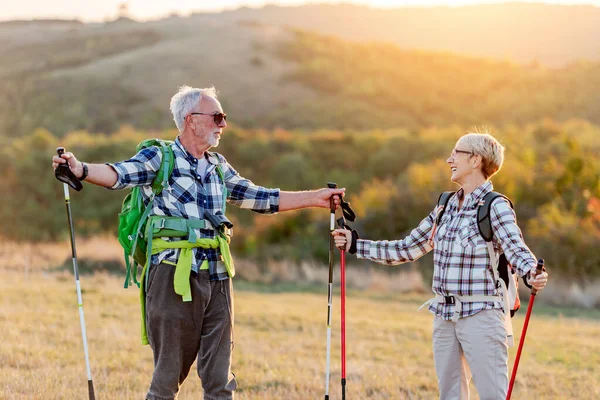 Dağlarda yürüyüş yapan mutlu yaşlı çift