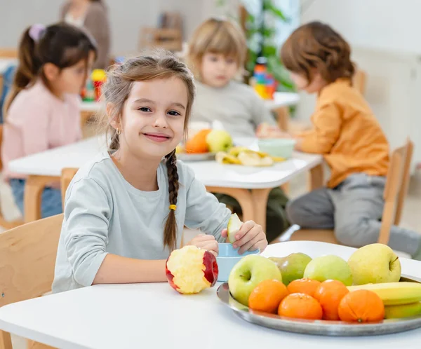 stock image children eating fruits at lunch break in kindergarten