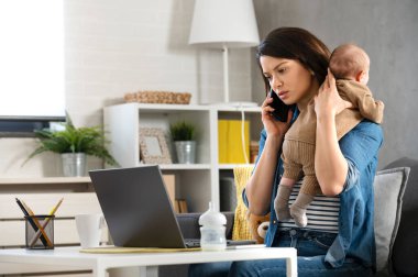 Genç anne evde bebekle çalışıyor.