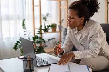 Genç Afrikalı Amerikalı kadın evde çalışıyor.