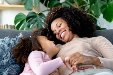 Afro-Amerikan anne ve kızı evde birlikte vakit geçiriyorlar.