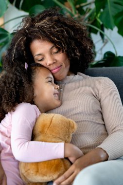 Afro-Amerikan anne ve kızı evde birlikte vakit geçiriyorlar.