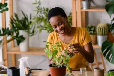Bitkilerle ilgilenen Afrikalı Amerikalı kadın çiçekçi. 