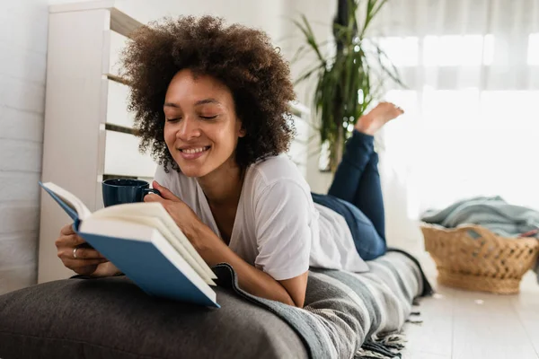 stock image african american woman reading book at home
