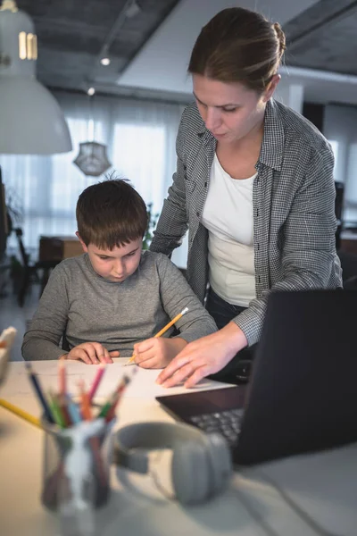 母は子供がノートパソコンの前で宿題をするのを助ける 家庭教育のライフスタイルコンセプト — ストック写真